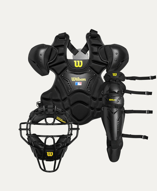 A comprehensive set of black umpire gear including a face mask, chest protector, and leg guards, all branded with the Wilson logo.